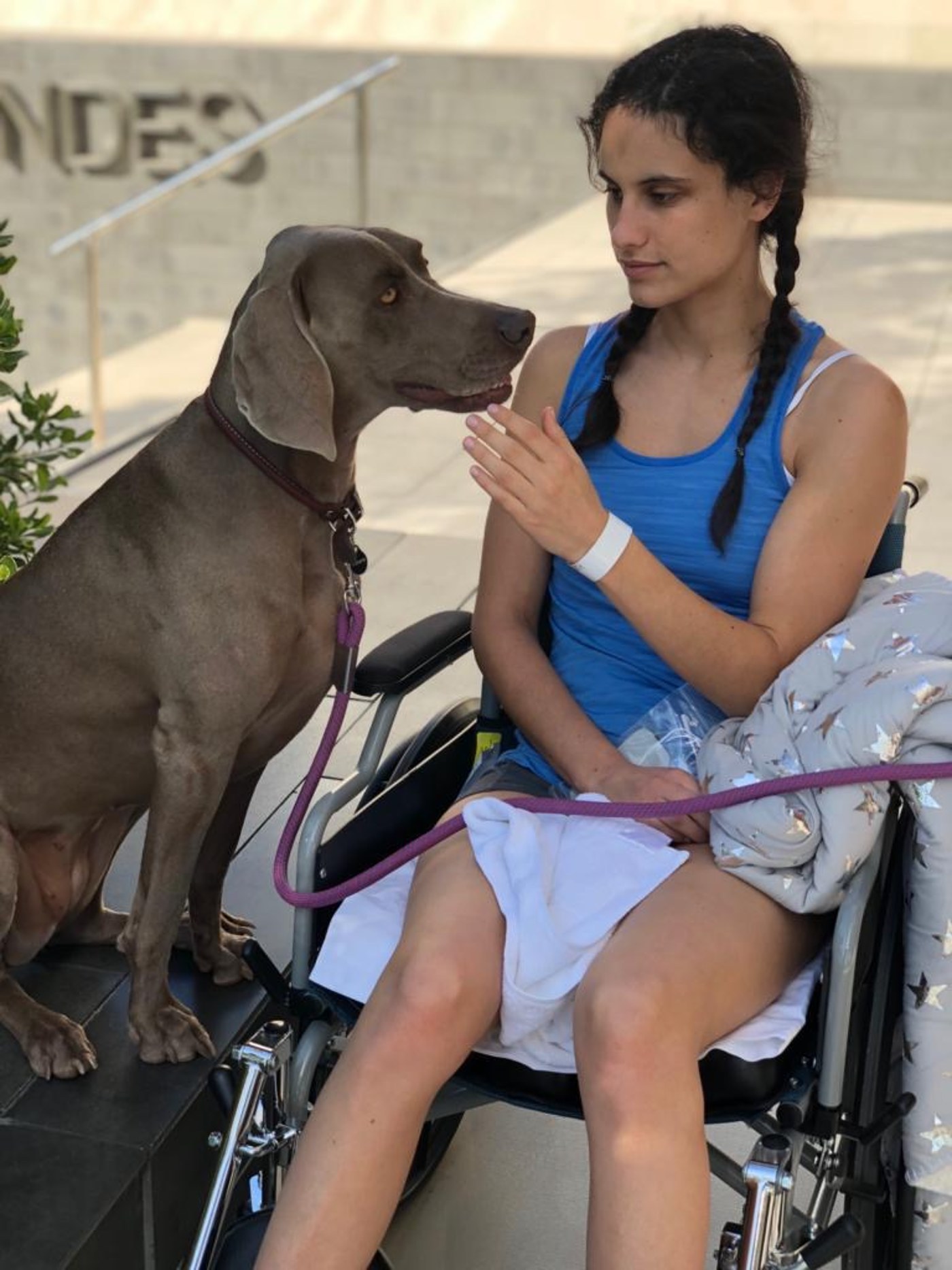 Karina en silla de ruedas junto a un perro de terapia